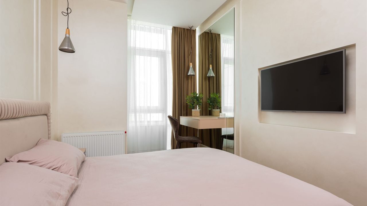 Bedroom TV mounted flat inside a recessed wall niche