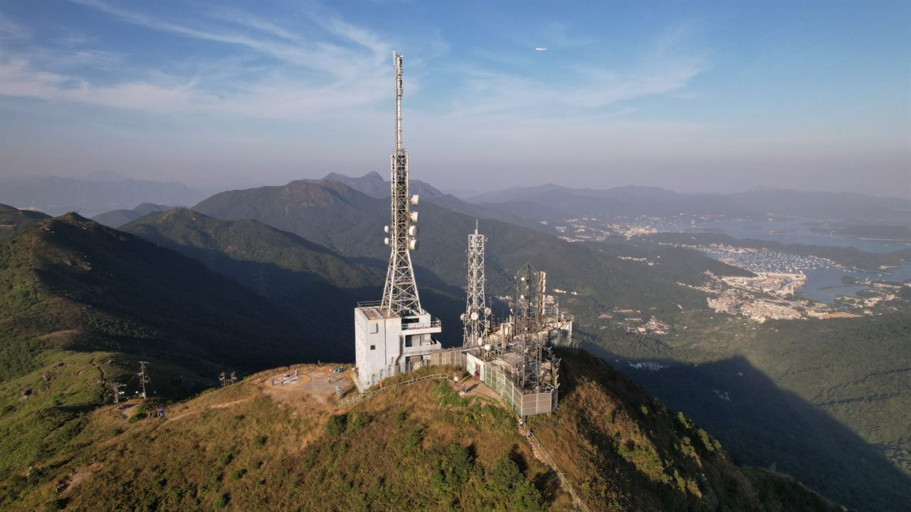 Broadcast tower on a hilltop above a valley, the kind of transmitter a rotor aims toward