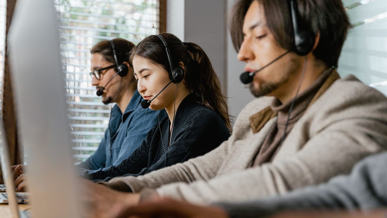 Call center operators wearing headsets working at computers