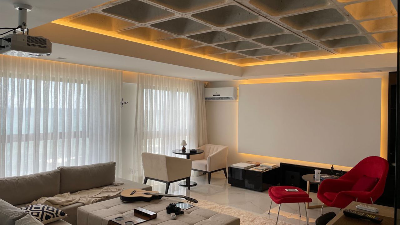 Video projector mounted on a ceiling bracket in a living room