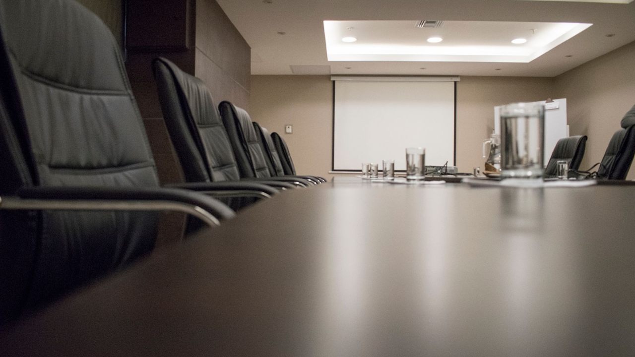 Conference room with a pull-down projection screen at the end of the table