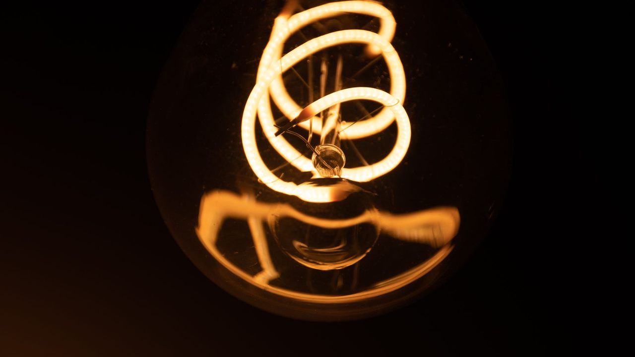 Glowing coiled filament inside a clear glass bulb