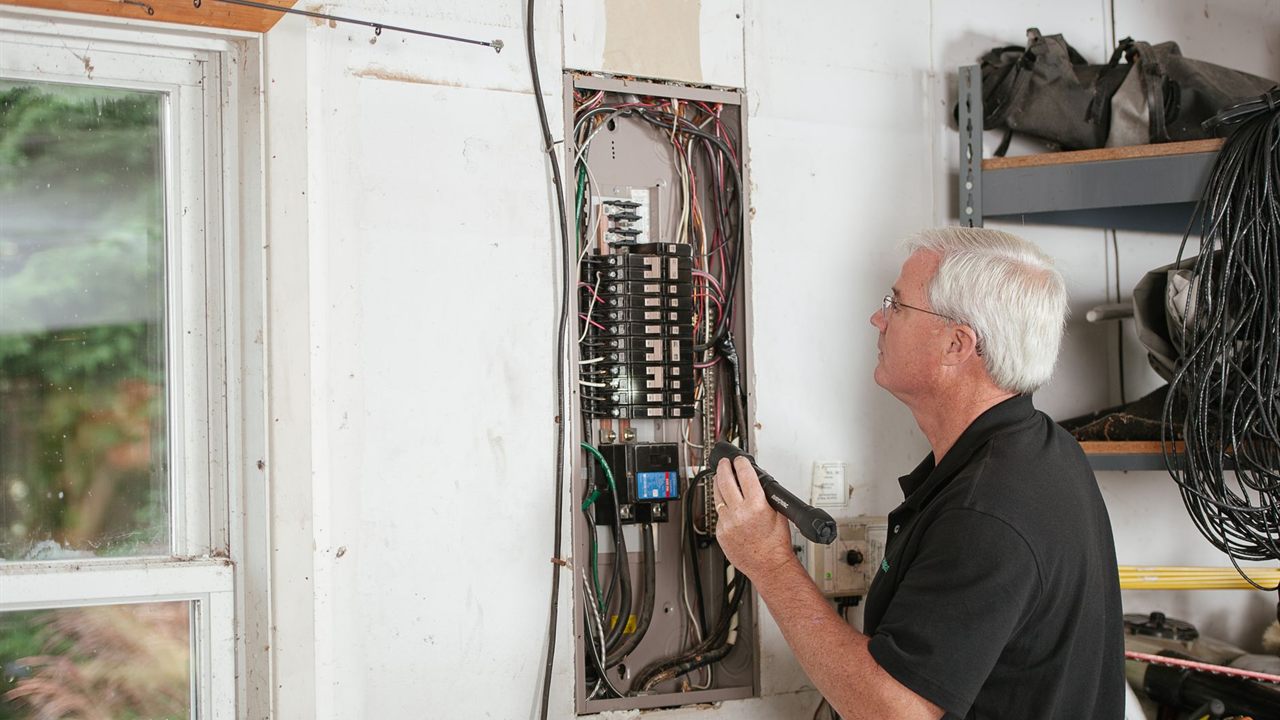Installer running cable through the framing of a house