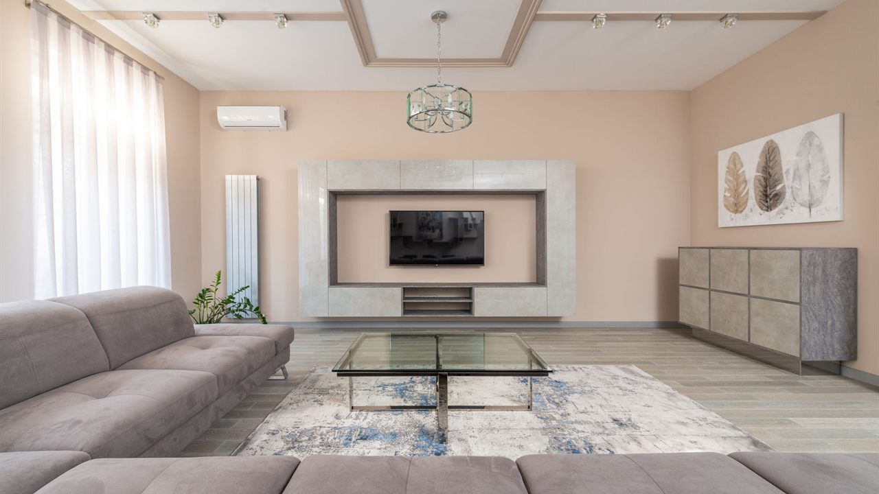 Living room TV mounted in a wall unit across the room from the sofa