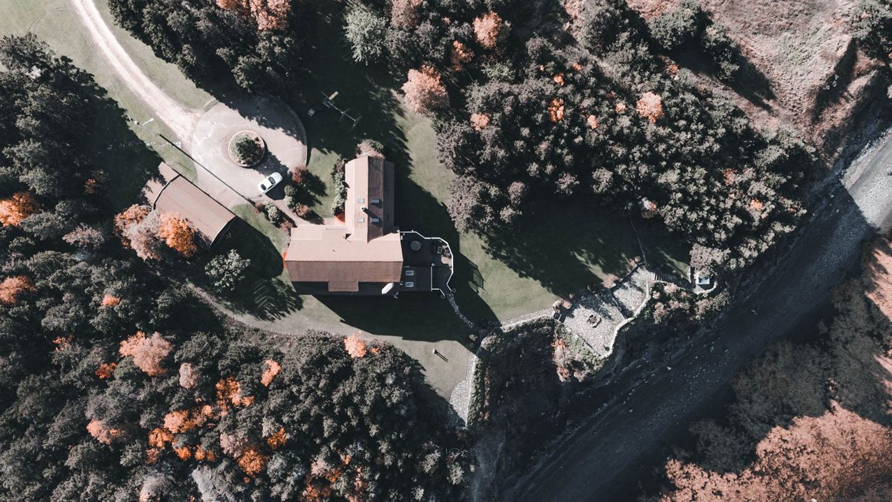 Rural house surrounded by tall trees, a site where an outdoor antenna has to clear the tree line