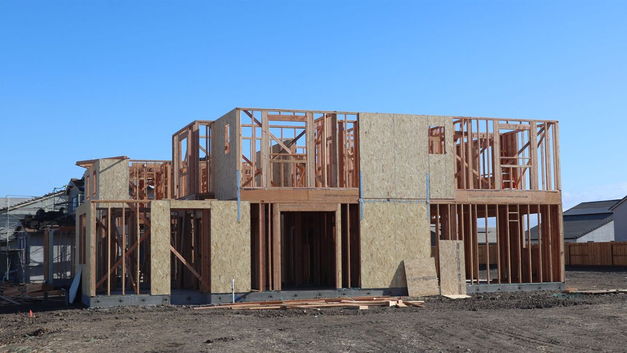Timber framed house under construction with exposed wall studs