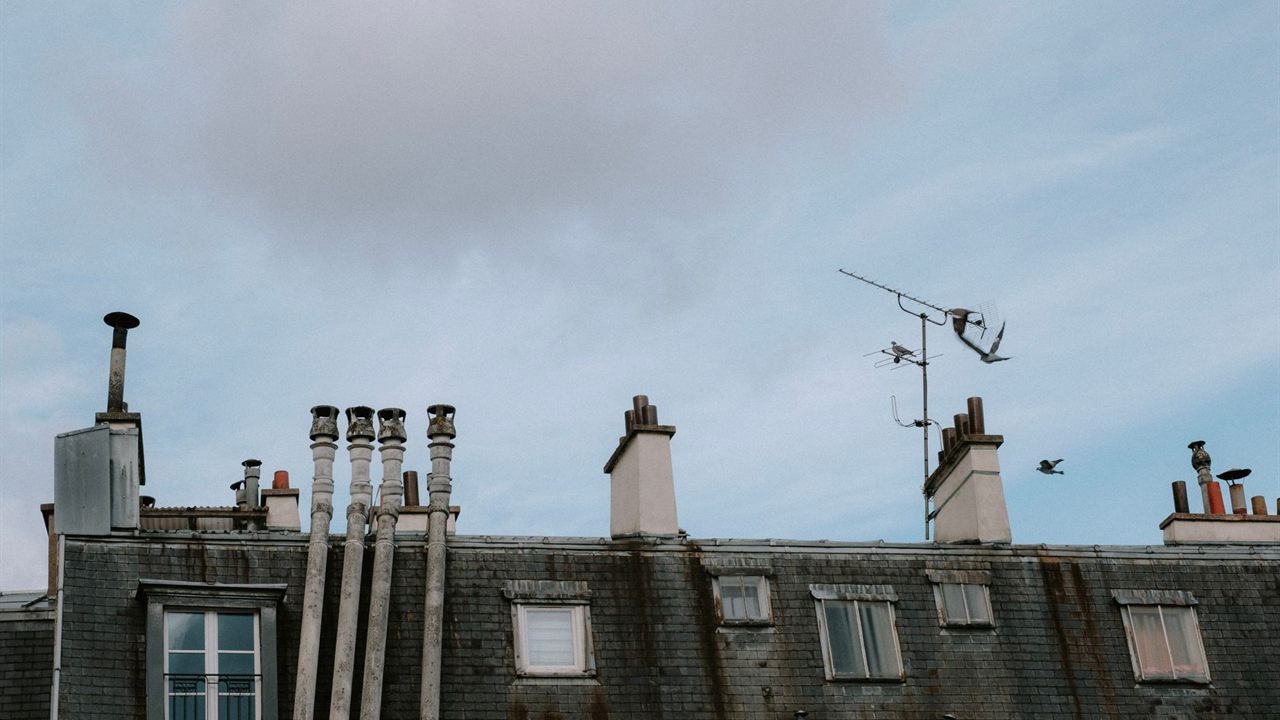 Rooftop TV aerial on a chimney mast above a slate roof